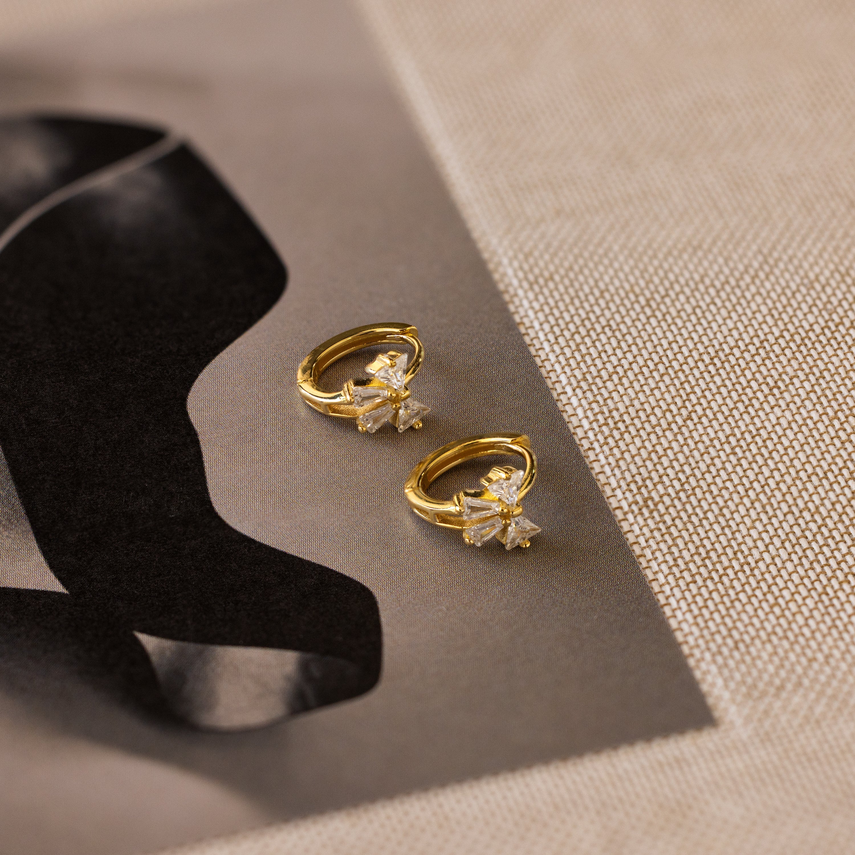 Little hoop earrings with a sparkly bow.